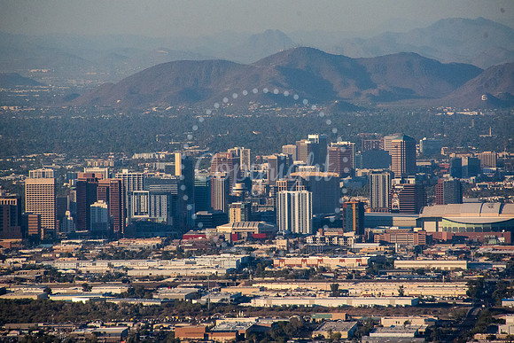 Aerial view of the Phoenix, Arizona skyline at sunset with desert mountains in the background