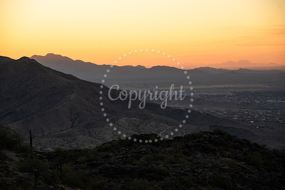 Golden sunset over layered desert mountains viewed from Dobbins Lookout in South Mountain Park, Arizona