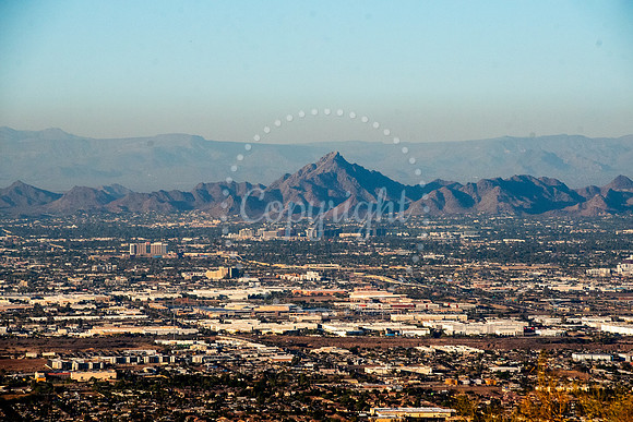A panoramic view of Camelback Mountain in Phoenix, Arizona with the urban cityscape and layered desert mountains in the distance