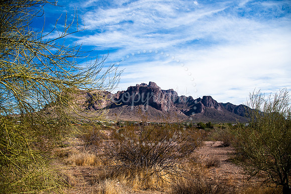 Superstition Mountain in Arizona framed by desert brush under cloudy blue sky landscape photography print